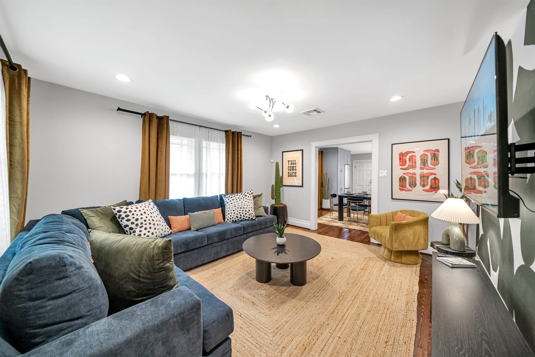 Navy sectional with colorful gallery wall and jute rug, finished by the Reborn group