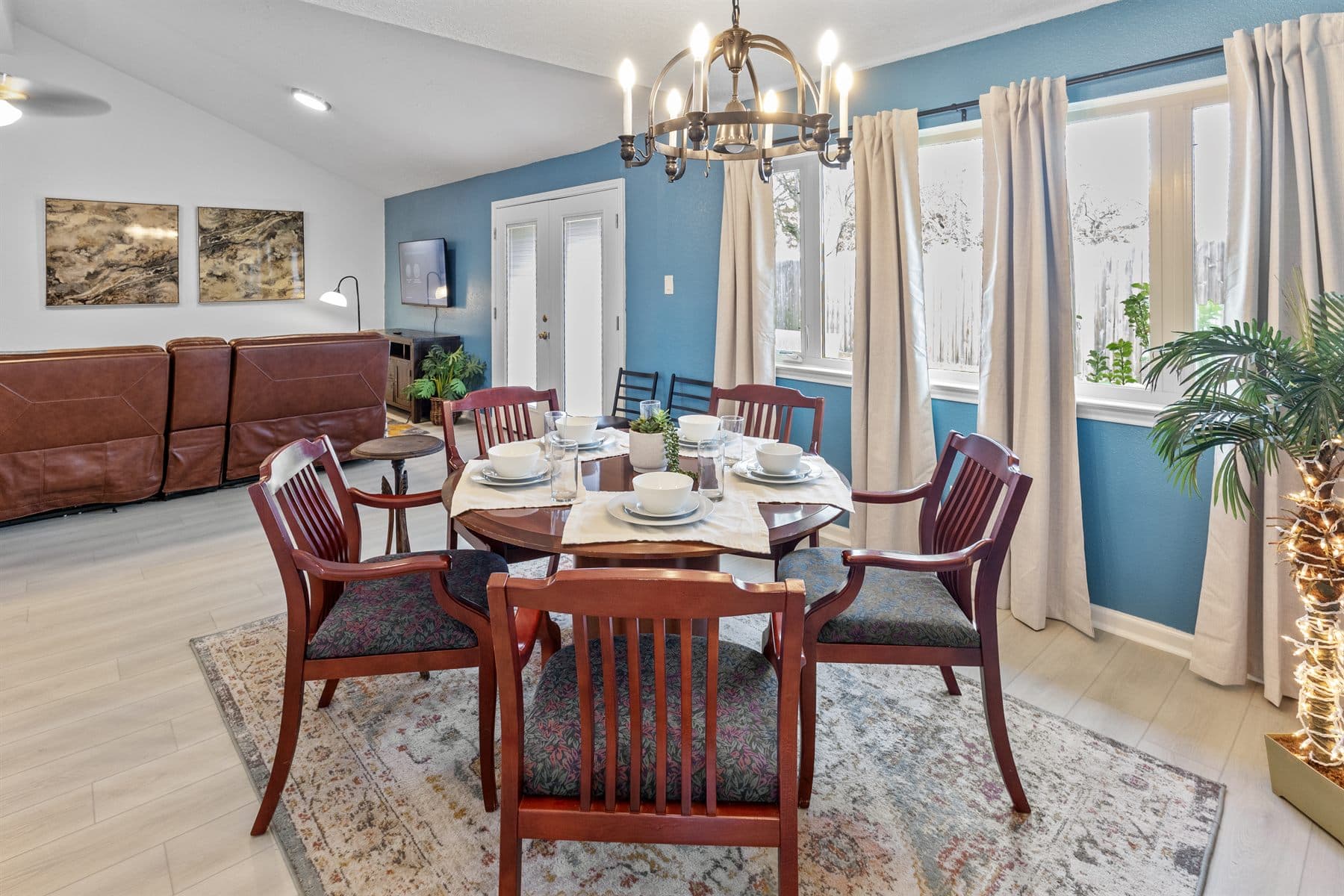 Dining room with blue accent wall, wood table and red chairs, finished by the Reborn group