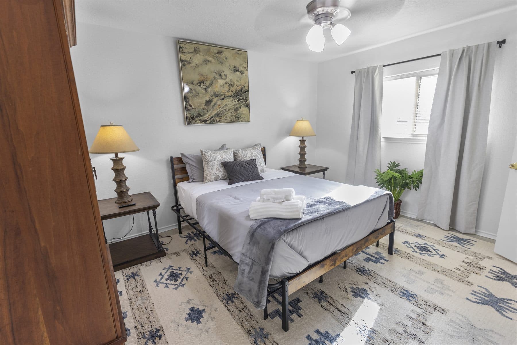 Bedroom with wrought iron bed and patterned rug, finished by the Reborn group