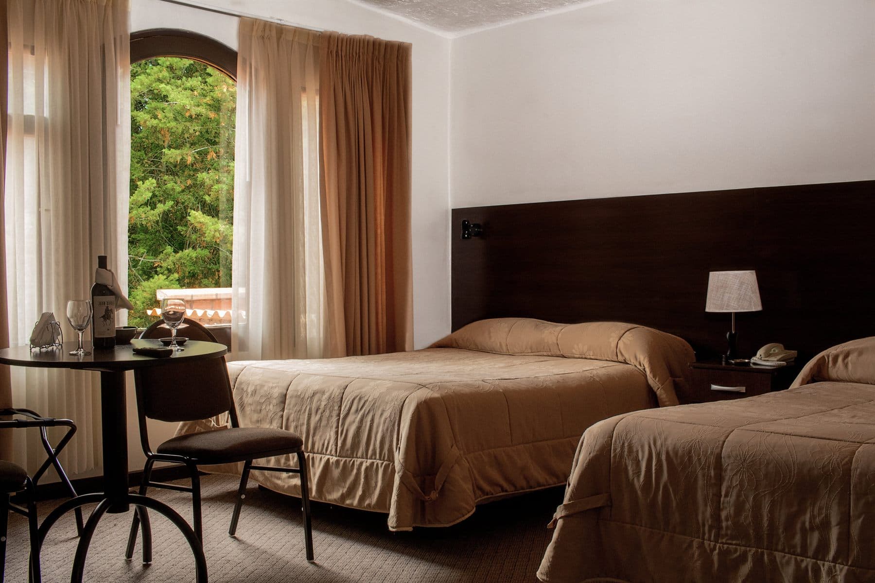Twin bedroom with potted plant and small dining table, finished by the Reborn group