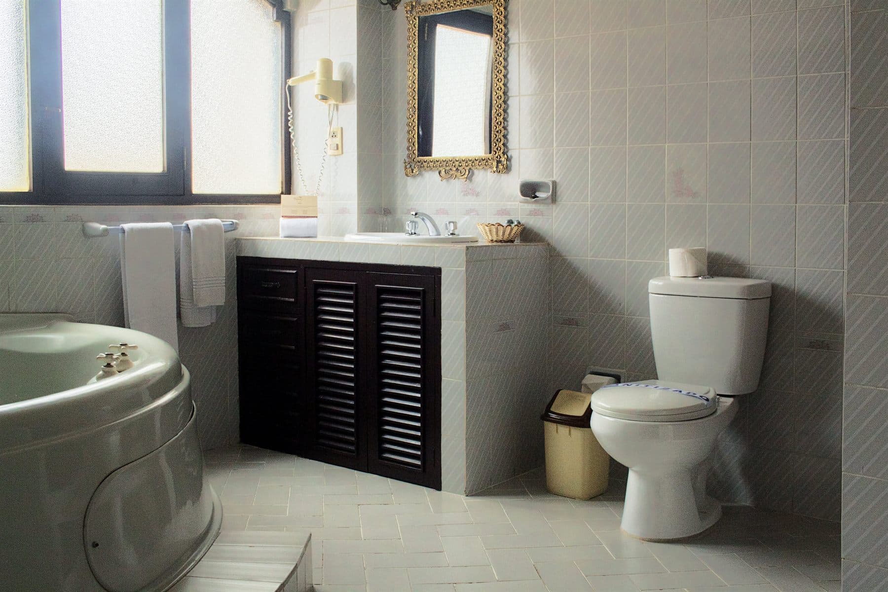 Corner jacuzzi tub with dark wood paneling and folded towels, finished by the Reborn group