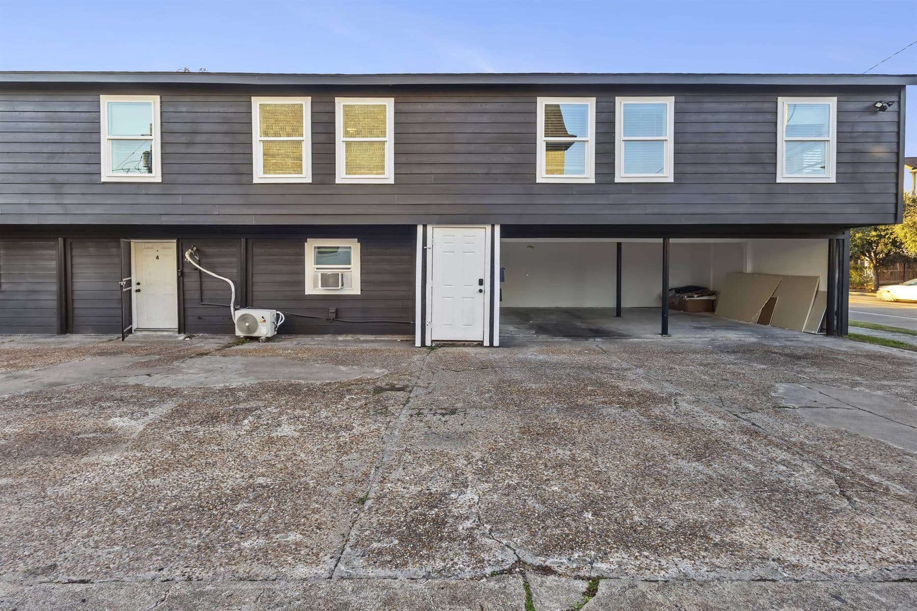 Two-story navy siding building exterior with white trim under blue sky, finished by the Reborn group