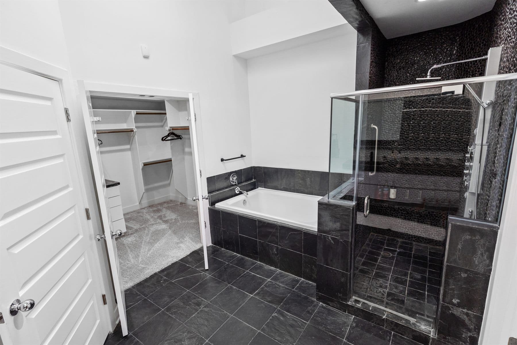 Black tile bath with soaking tub and glass shower, finished by the Reborn group