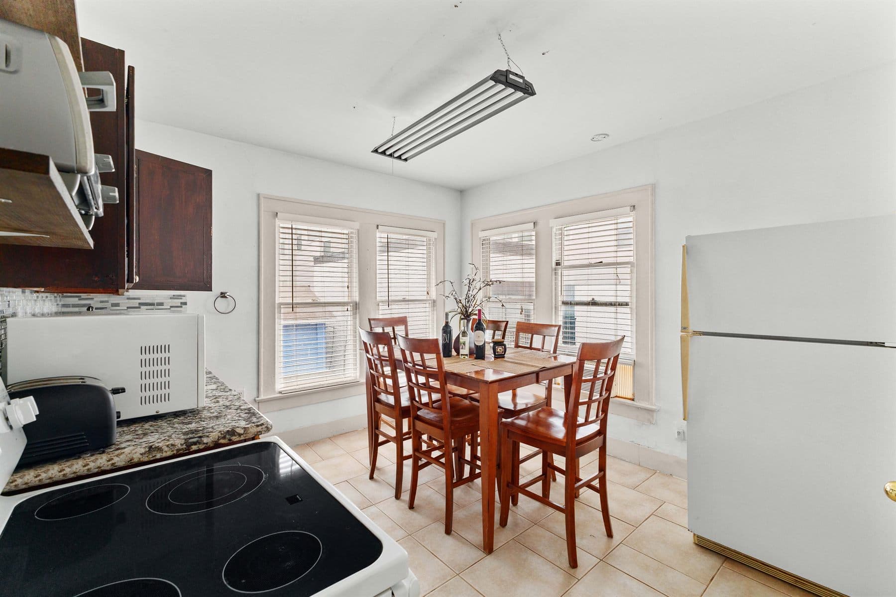 Kitchen with dark wood cabinets and dining table by the window, finished by the Reborn group