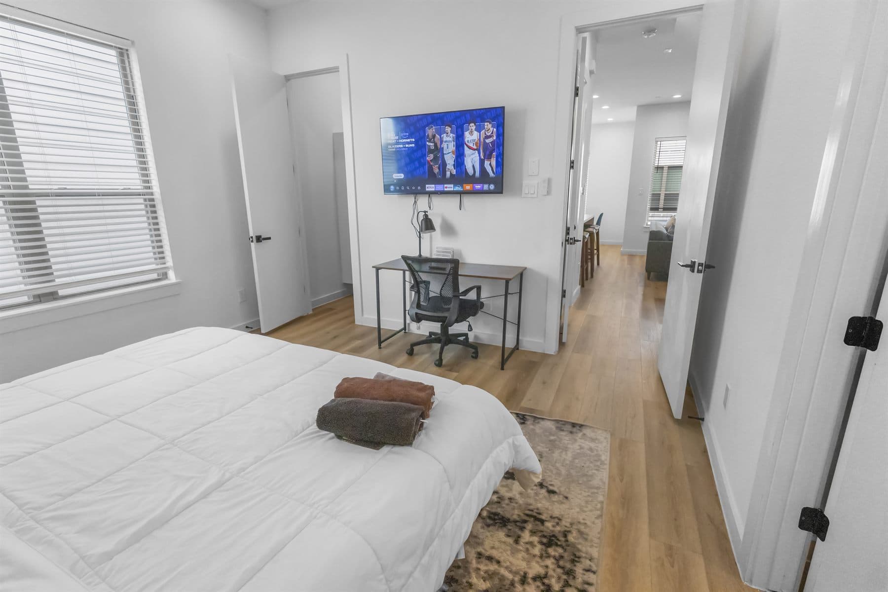 Staged bedroom with framed art and neutral linens, finished by the Reborn group