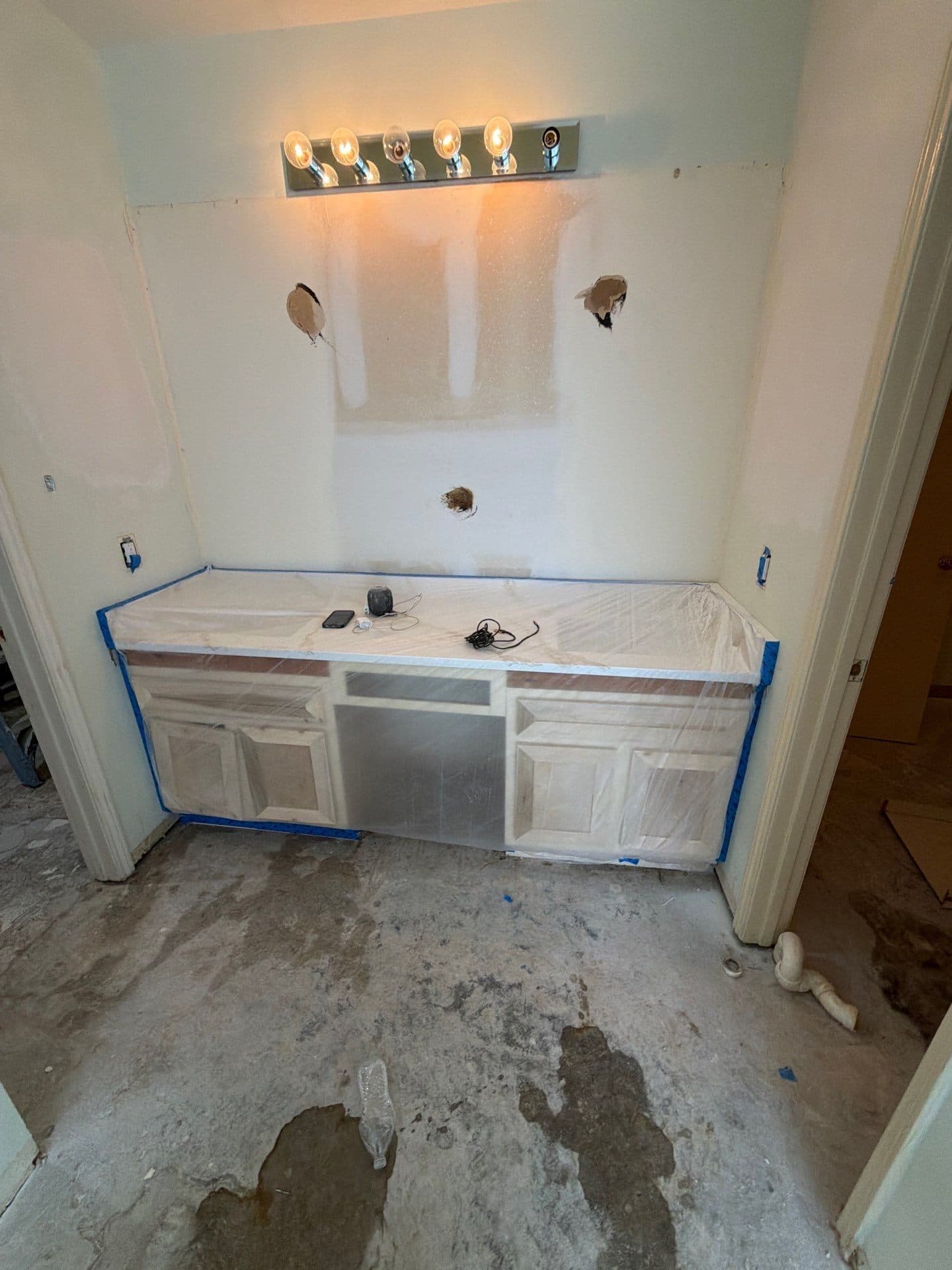 Vanity wall lit, new cabinetry wrapped for protection