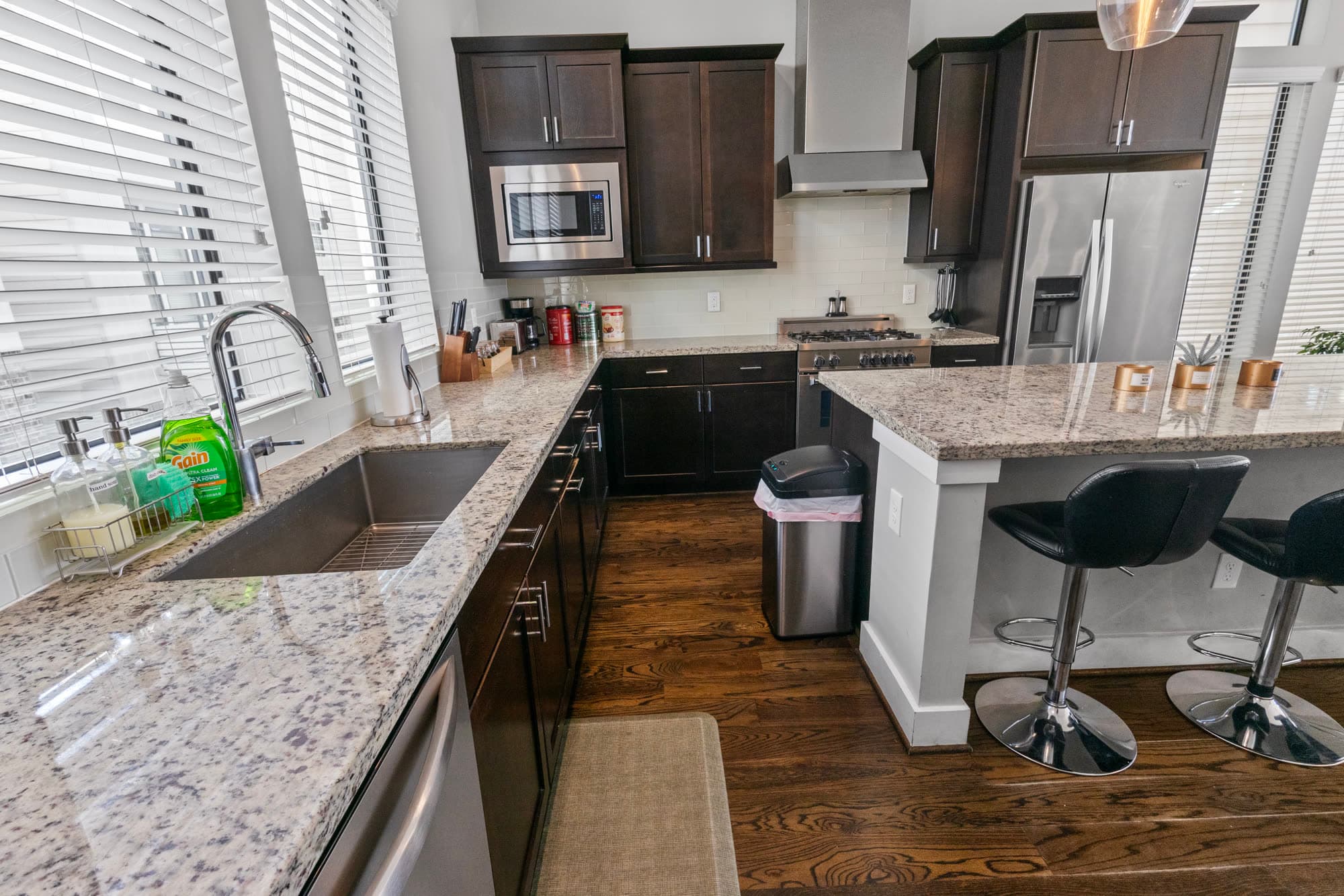 Kitchen island with stainless appliances and bar seating, finished by the Reborn group