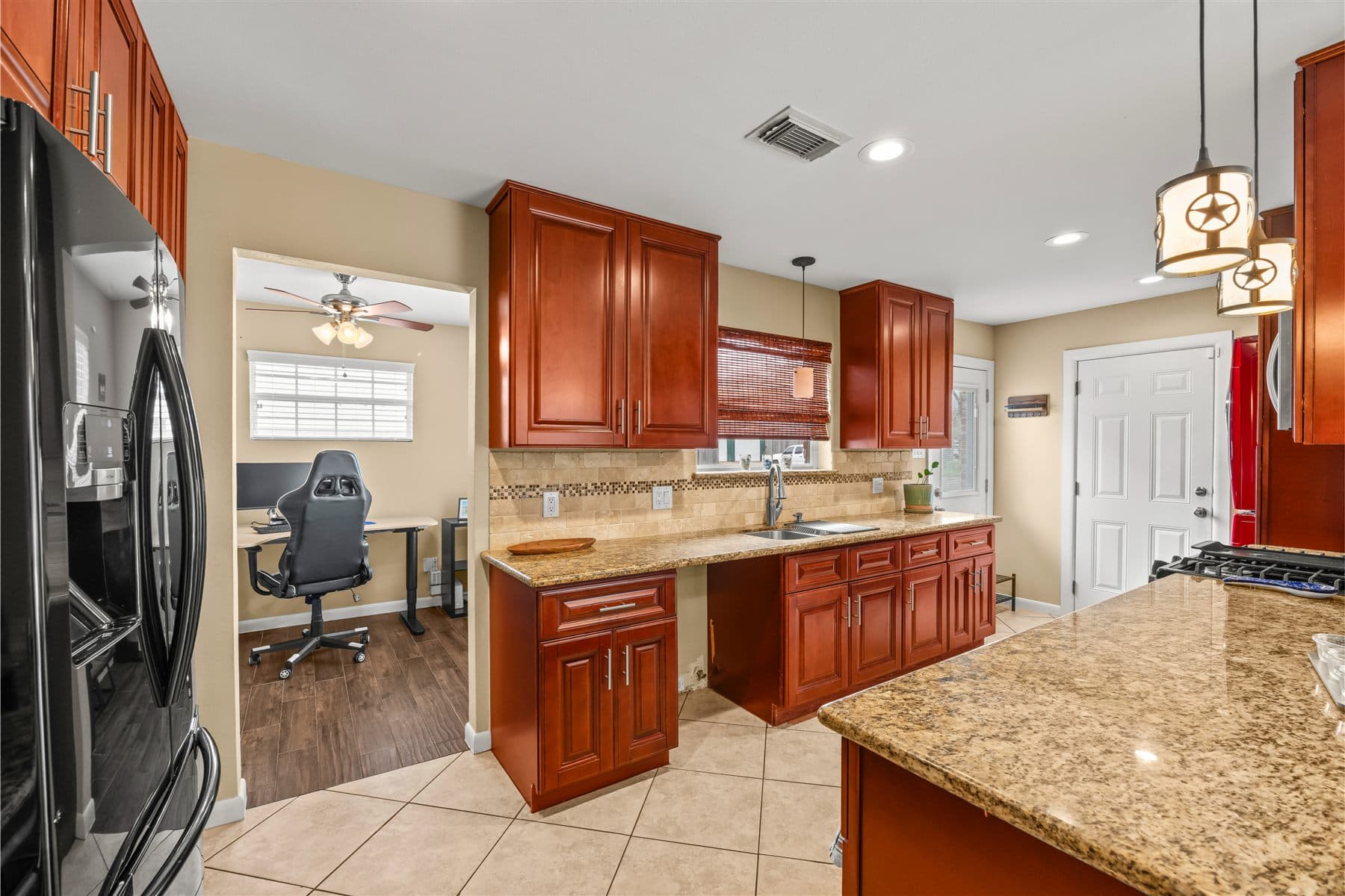 Kitchen run with granite island and full-height cabinets, finished by the Reborn group