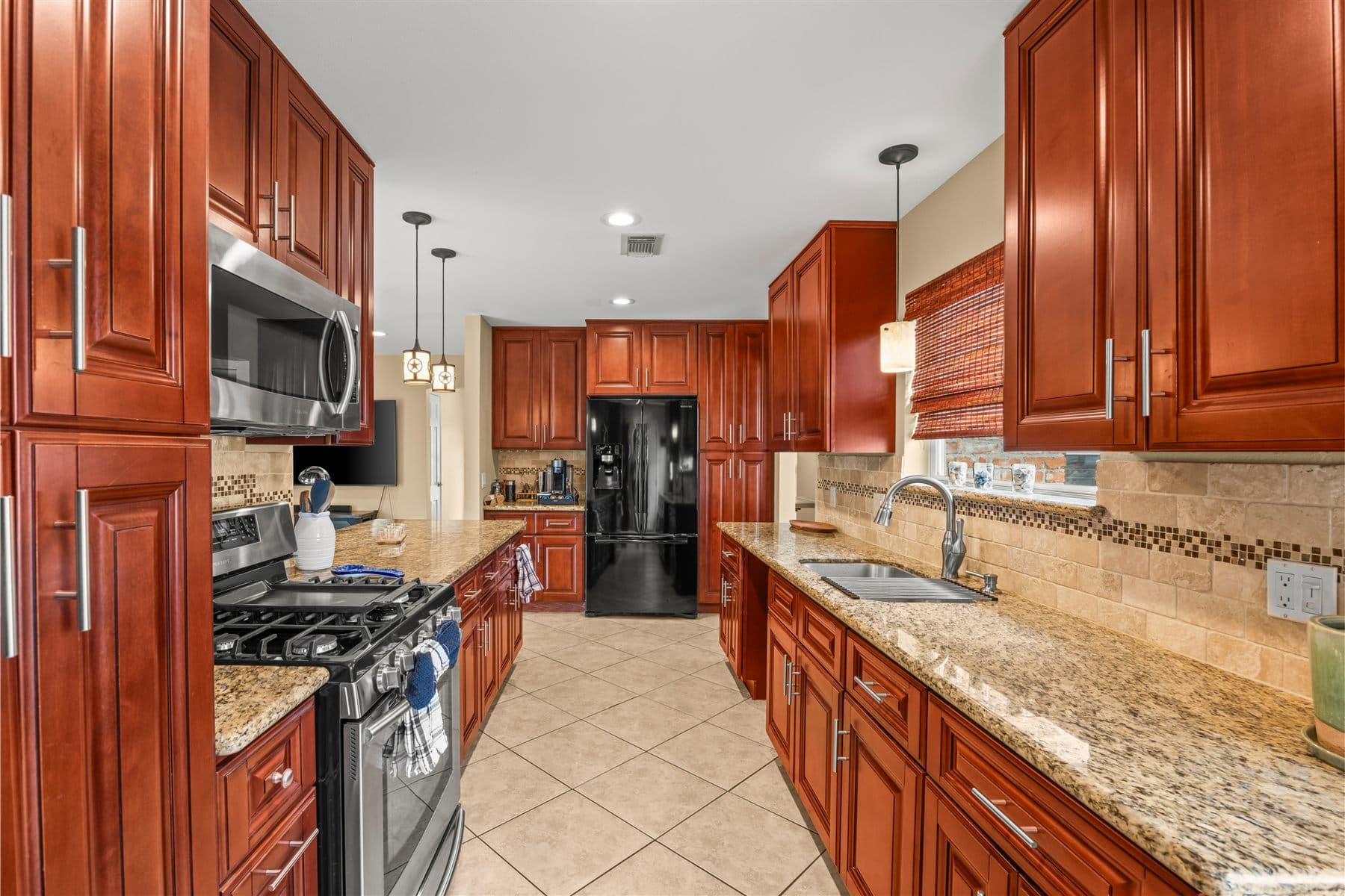 Galley view of the kitchen granite counters and gas range, finished by the Reborn group