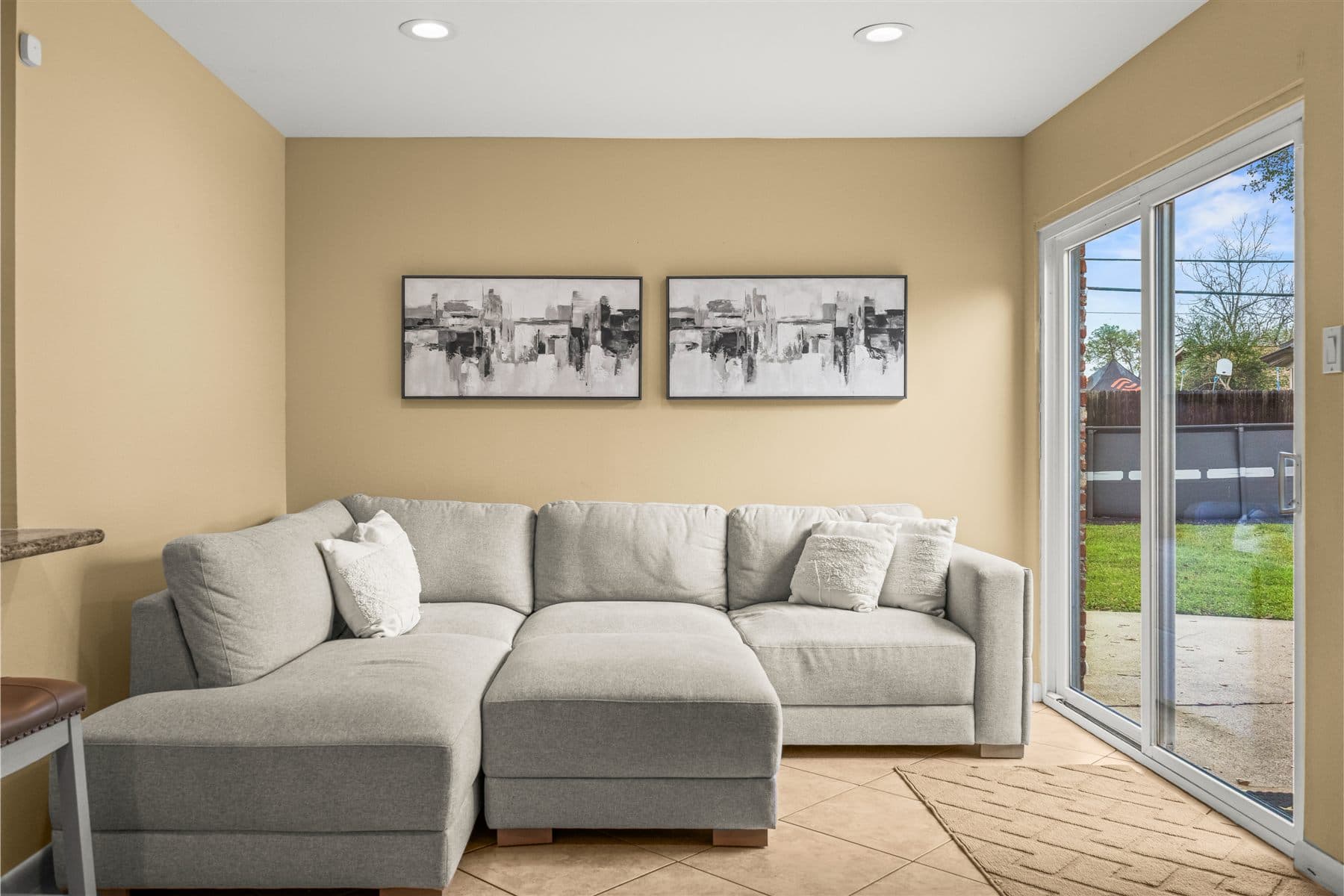 Living room with gray sectional opening to the back patio, furnished by the Reborn group
