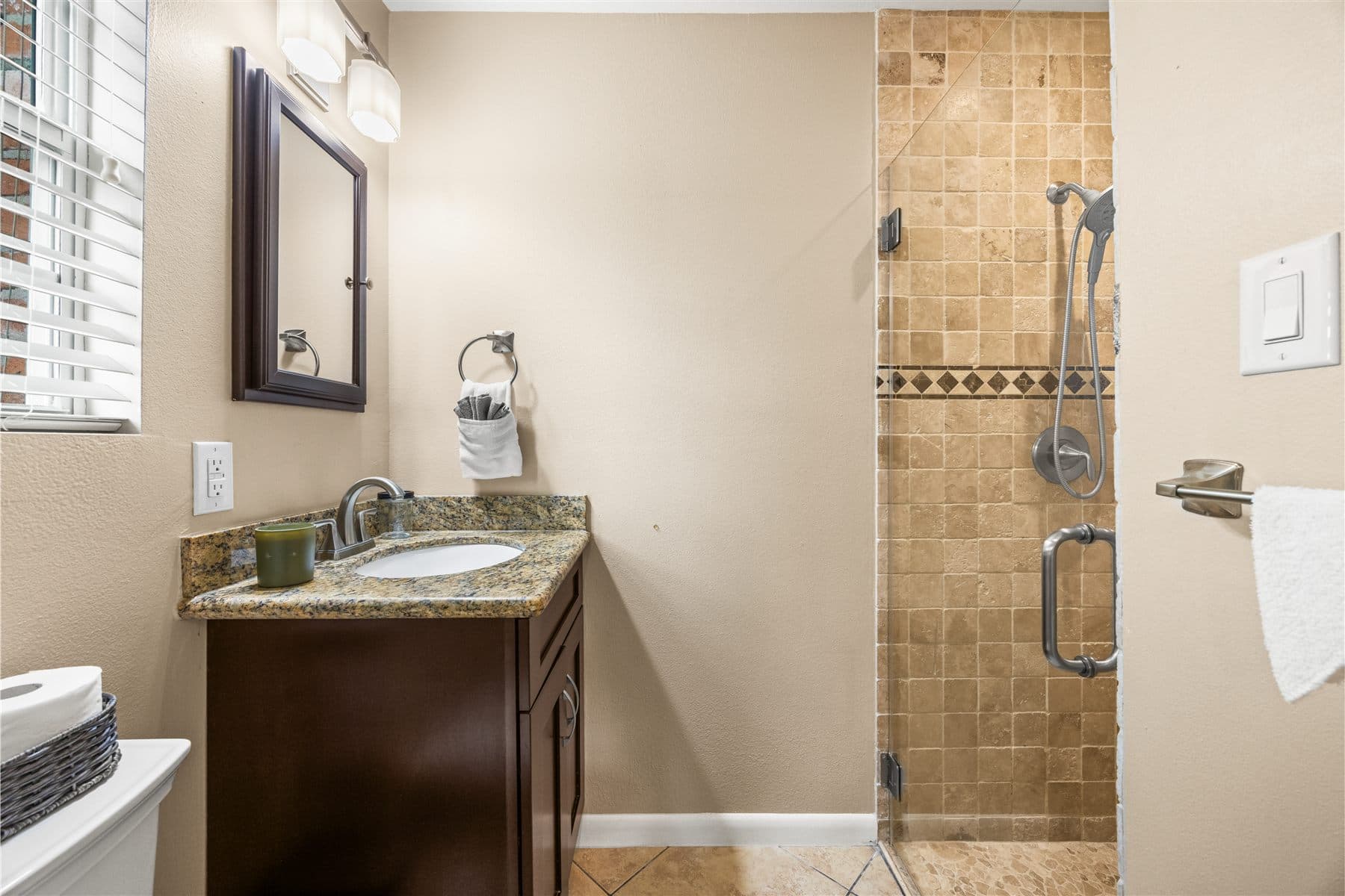 Bathroom with granite vanity and glass walk-in shower, finished by the Reborn group