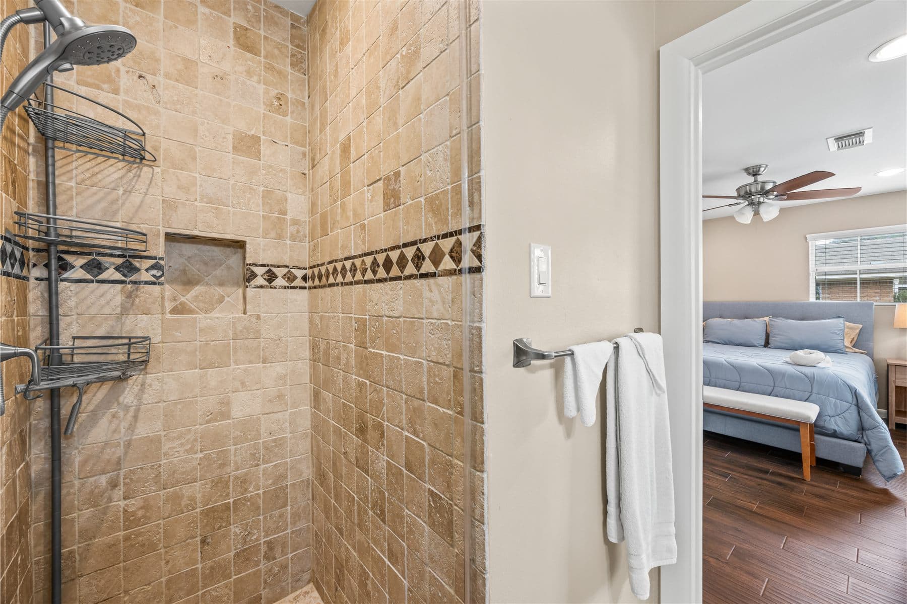 Tiled walk-in shower with an inlaid border, finished by the Reborn group