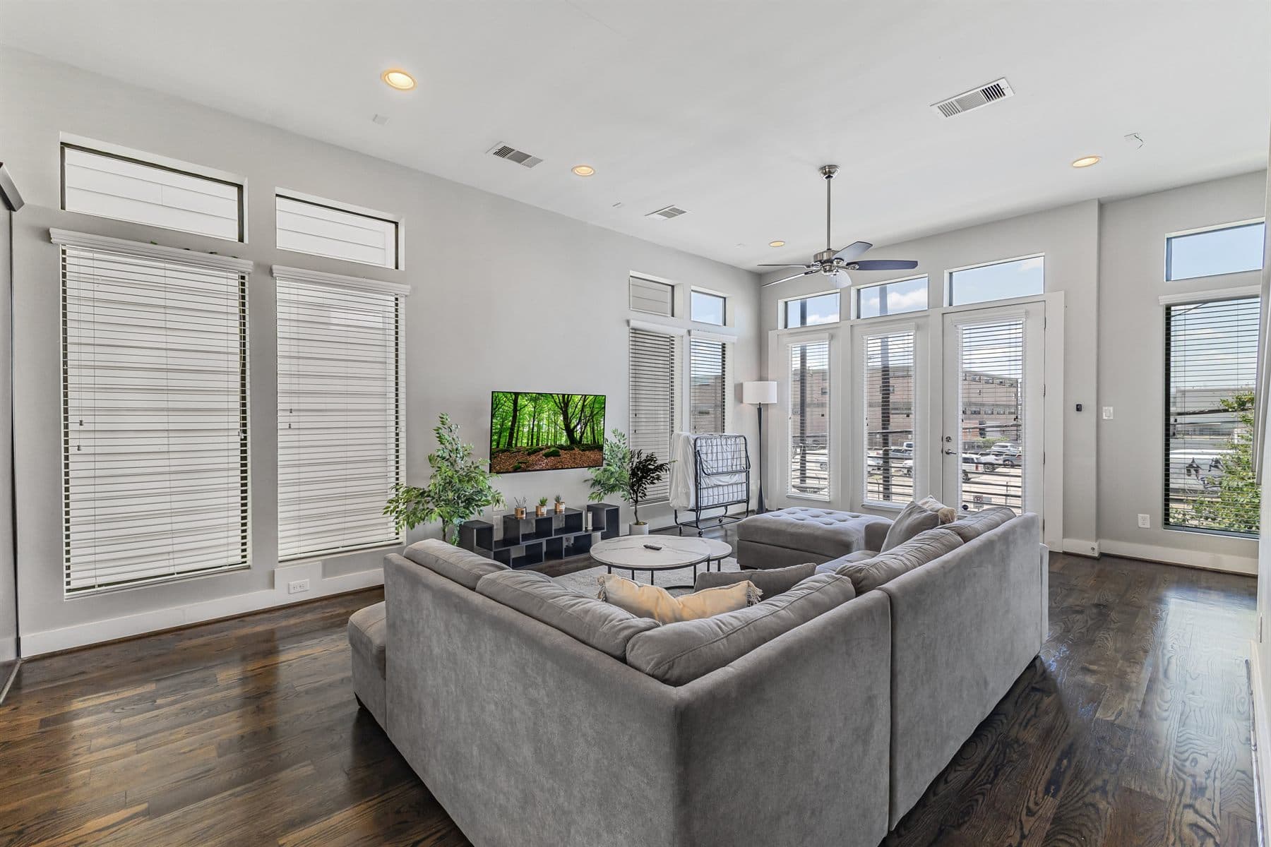 Bright great room with floor-to-ceiling windows and staircase, finished by the Reborn group