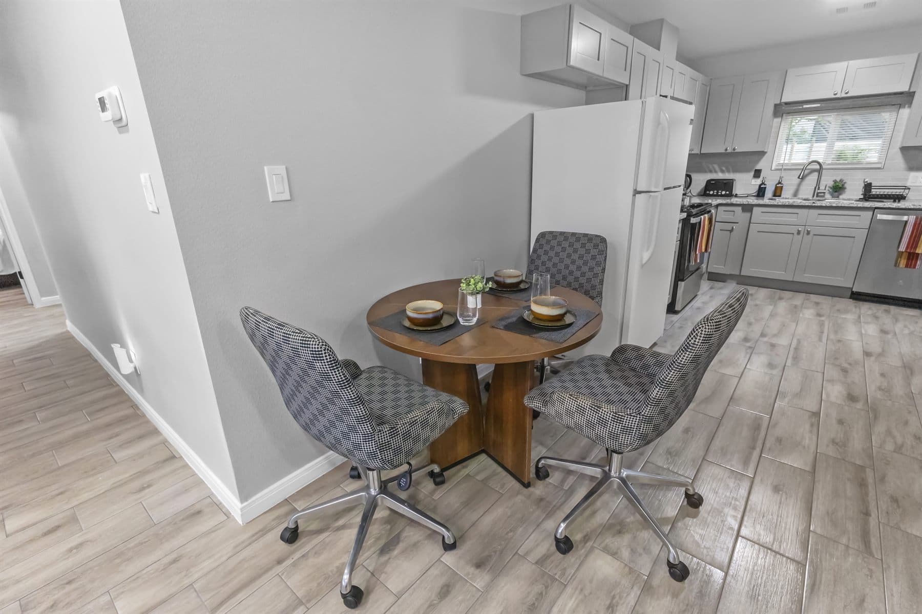 Open kitchen and dining area with wood floors, finished by the Reborn group