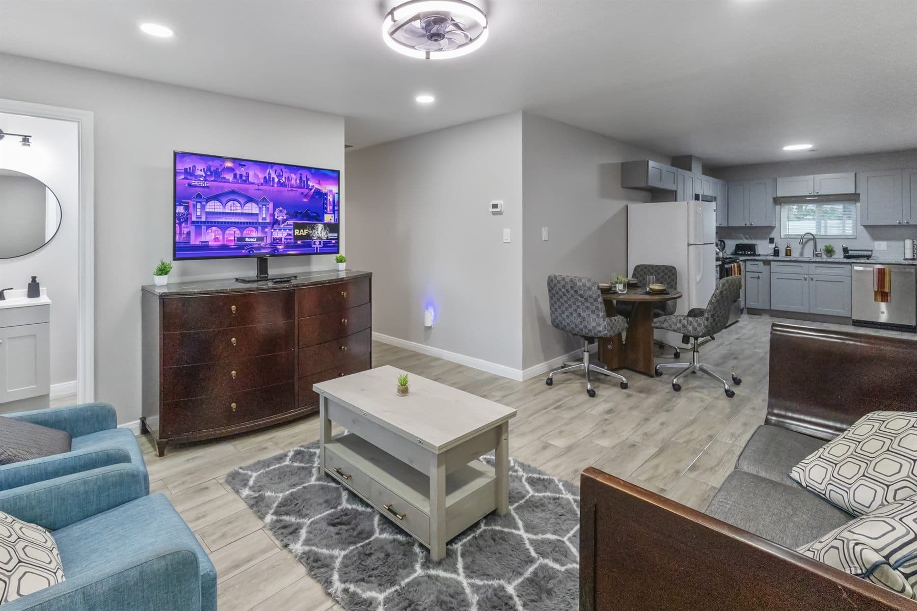 Living room with blue accent chairs and patterned rug, finished by the Reborn group