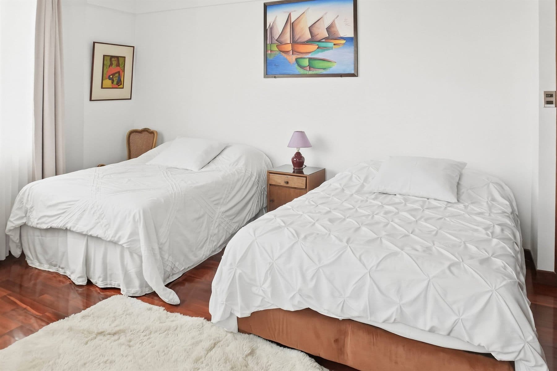 Twin bedroom with crisp white linens, finished by the Reborn group