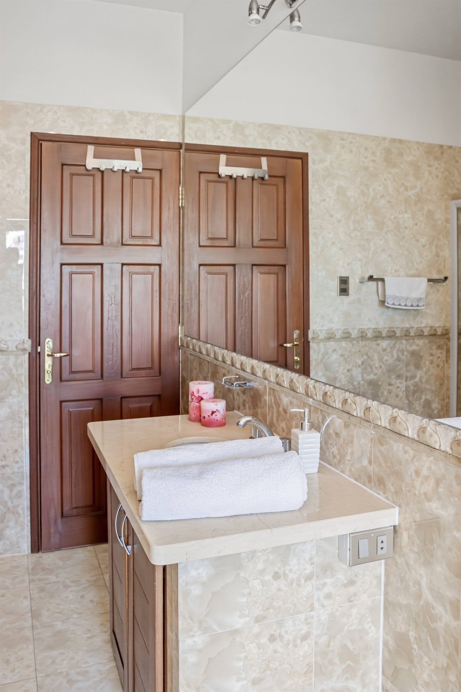 Marble vanity with folded towels and elegant fixtures, finished by the Reborn group